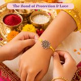 Designer lotus charm rakhi with delicate silver flower charm and vibrant yellow cord for raksha bandhan protection gift