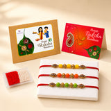 Set of three colorful handmade designer rakhi bracelets with gold-toned beads and red cotton strings for raksha bandhan gift