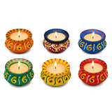 Vibrantly painted handmade matki clay diya lamps in assorted colors with intricate patterns holding lit candles for diwali decor