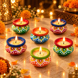 Handmade colorful clay matki diya filled with wax and lit candles for diwali pooja festival and home decor