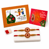Designer gold-colored rakhi with red beads and central gemstone featuring intricate handcrafted designs for Raksha Bandhan