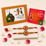Designer rakhi set with gold-colored rakhi featuring red gemstone centerpiece and intricate detailing on white tray