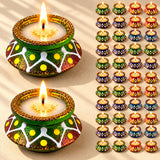 Handmade clay matki diya candle holders in green and gold with white and yellow patterns for diwali pooja and décor