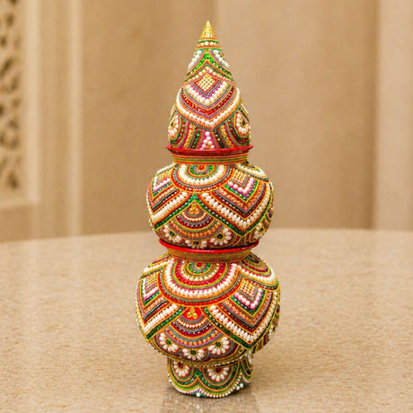 Decorative kalash for pooja made of mild steel with vibrant gold red green pink and white beadwork for festival decor