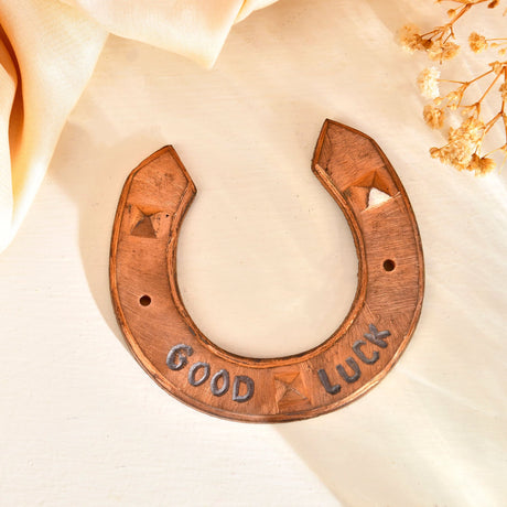 Copper-colored horseshoe with decorative markings for Western theme wall decor and good luck