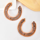 Pair of copper horseshoe earrings suitable for rustic wedding, birthday, or housewarming decor