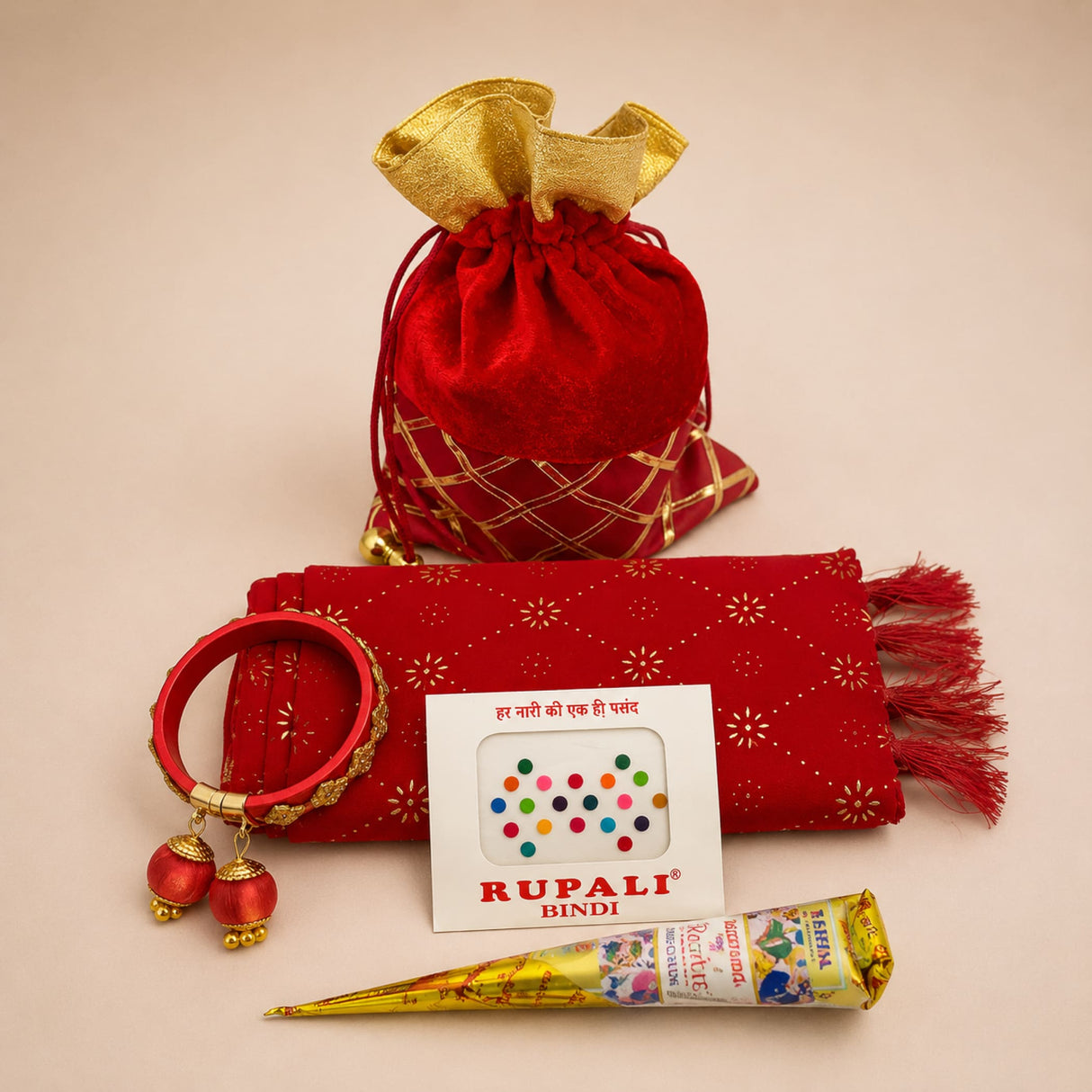 Red velvet drawstring potli bag with gold lattice detailing and golden ruffled top for Navratri gift hamper and puja return gifts