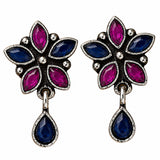 Indian oxidized floral earrings with vibrant fuchsia and deep blue stones in silver frame for Diwali and wedding wear