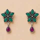 Silver oxidized floral earrings with six emerald green leaf stones and a dangling ruby teardrop for ethnic wear