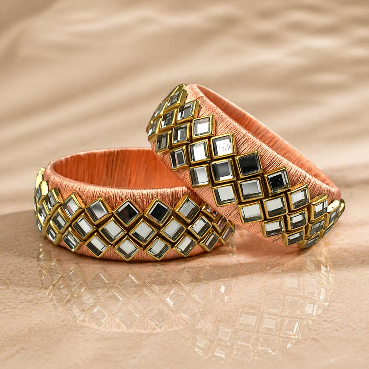 Peach satin Indian silk thread bangles with gold-trimmed mirrored squares for traditional bridal and gift use