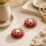 Vibrant pink and gold Indian tea light candle holders adorned with sparkling crystals for festive and home decor