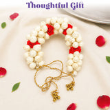 Traditional artificial jasmine gajra with delicate white and red flowers, golden bells, and braided cord for bridal hair