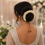 Traditional artificial jasmine gajra cream pearl hair accessory wrapped around sleek black bun for bridal use