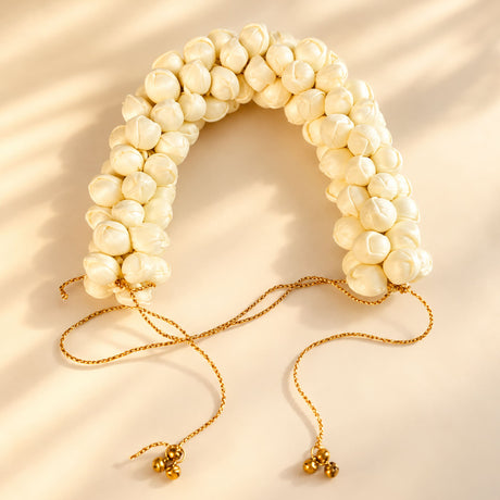 Traditional artificial jasmine gajra with cream pearl flower beads, gold-toned chains, and small bells for bridal hair decor