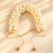 Traditional artificial jasmine gajra with cream pearl flower beads, gold-toned chains, and small bells for bridal hair decor