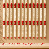 Rows of white and red jasmine garland floral strings hanging against beige wall with scattered petals for diwali decor