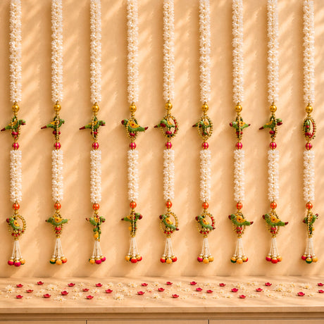 White floral garlands with colorful parrot and fruit motifs gold accents and tassels for indian wedding decor and pooja backdrop