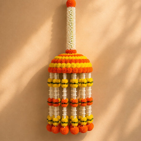 A jumbo artificial marigold flower jhoomar with vibrant orange and yellow pom-poms for indian themed celebrations