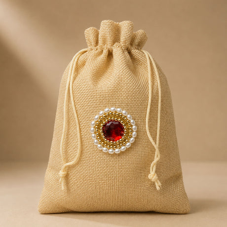 Beige jute potli bag with red gemstone and pearl embellishment for Eid gifts Punjabi wedding favors and jewelry organizer