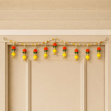 Kalash bead door toran with vibrant orange and yellow floral design gold accents and pom-pom tassels for festive decor