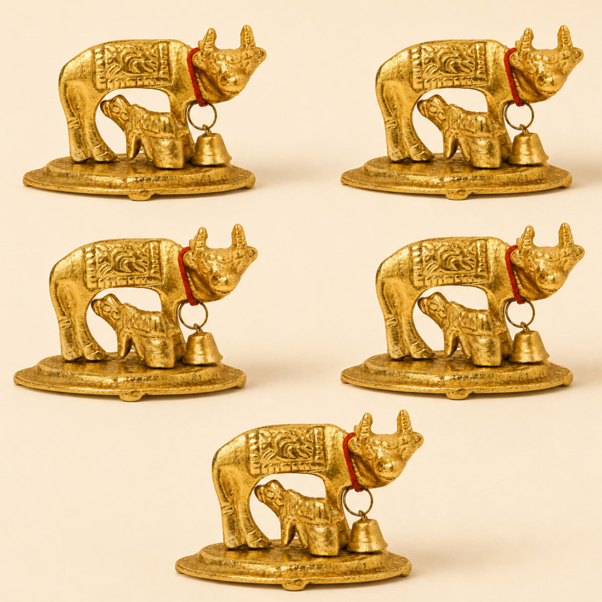 Golden metallic Kamadhenu cow and calf figurines with intricate engravings and red cords with bells brass finish statue
