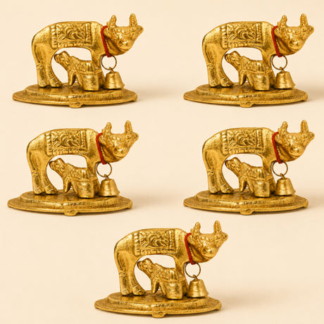 Golden metallic Kamadhenu cow and calf figurines with intricate engravings and red cords with bells brass finish statue
