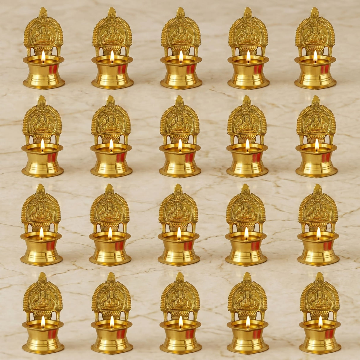 Golden brass Kamakshi Deepam oil lamps with intricate deity carvings and small lit candles for Diwali pooja