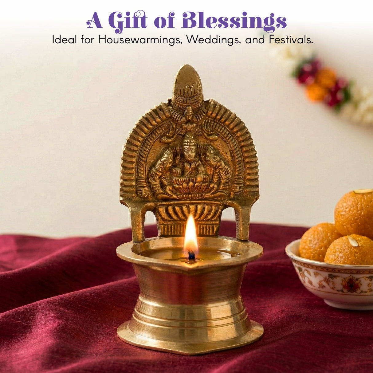 Golden brass Kamakshi deepam oil lamp with intricate deity carvings and lit flame for Hindu puja and home decor