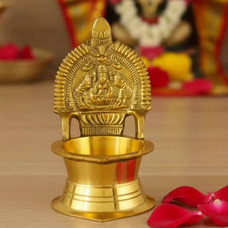Golden brass kamakshi deepam oil lamp with intricate deity carvings and ornate arches for hindu puja and home decor