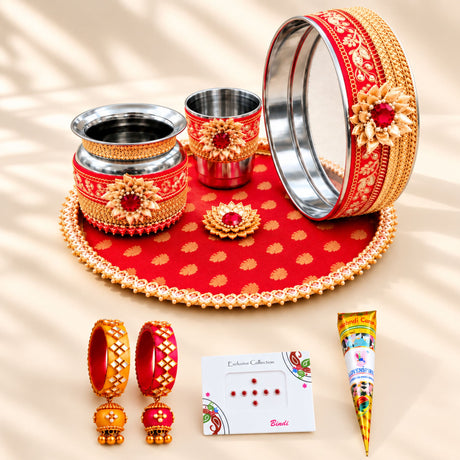 Red and gold decorative Karwa Chauth pooja thali set with intricate floral patterns for traditional Indian festive use