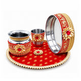 Karwa chauth pooja thali set with red and gold ornate design, floral patterns, red gemstones, and silver interiors