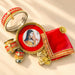 Red and gold embellished karwa chauth pooja thali set with circular mirror, pearl-trimmed containers, and decorative fabric