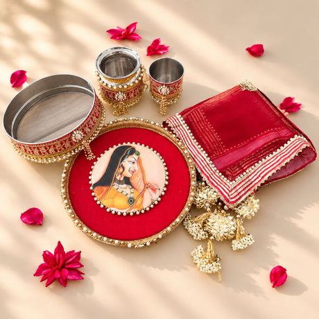 Red velvet karwa chauth pooja thali set with gold beaded border and central portrait of ornate indian woman in yellow attire