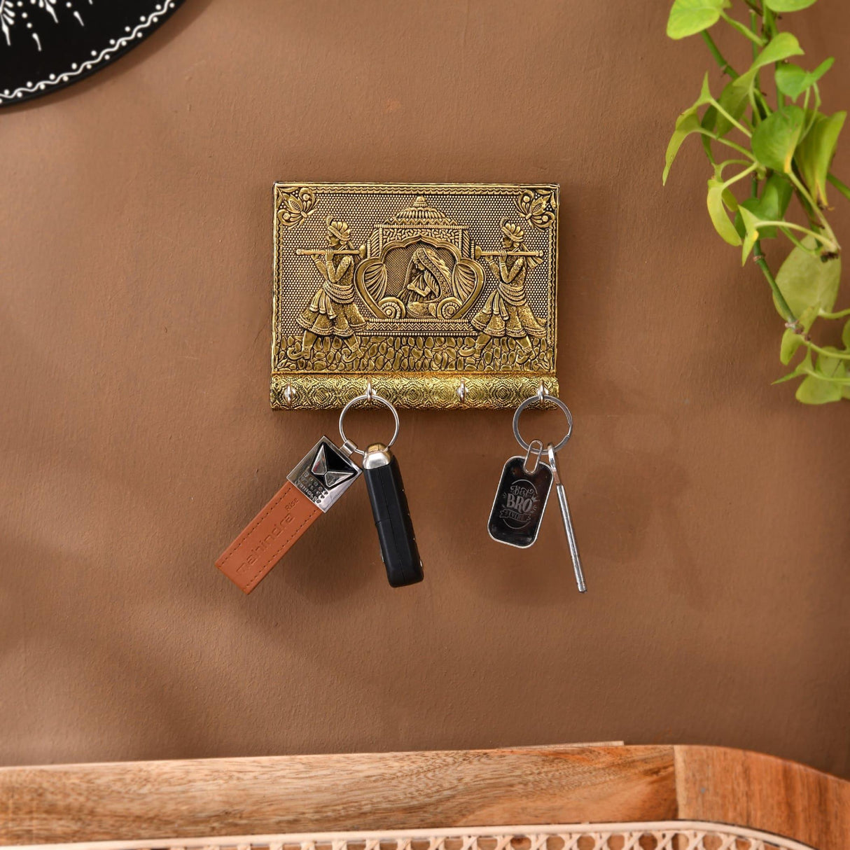 Gold ornate Indian doli key holder with embossed figures, 4 wall hooks