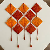 Vibrant orange and red diamond-shaped kites with gold bead accents and braided tails in premium haldi kumkum mini packs for indian wedding and festive use