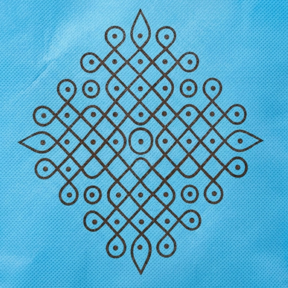 A light blue non woven gift bag with a black intricate kolam print pattern for indian wedding and puja use