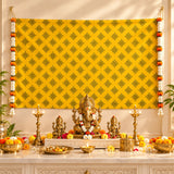 Golden ganesha idol with white and orange floral garland seated on pedestal amid ceremonial items in kolam rangoli backdrop set for pooja and festive decor