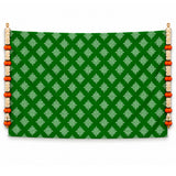 Green kolam rangoli print backdrop with white geometric patterns and orange white beaded tassels for Diwali decor