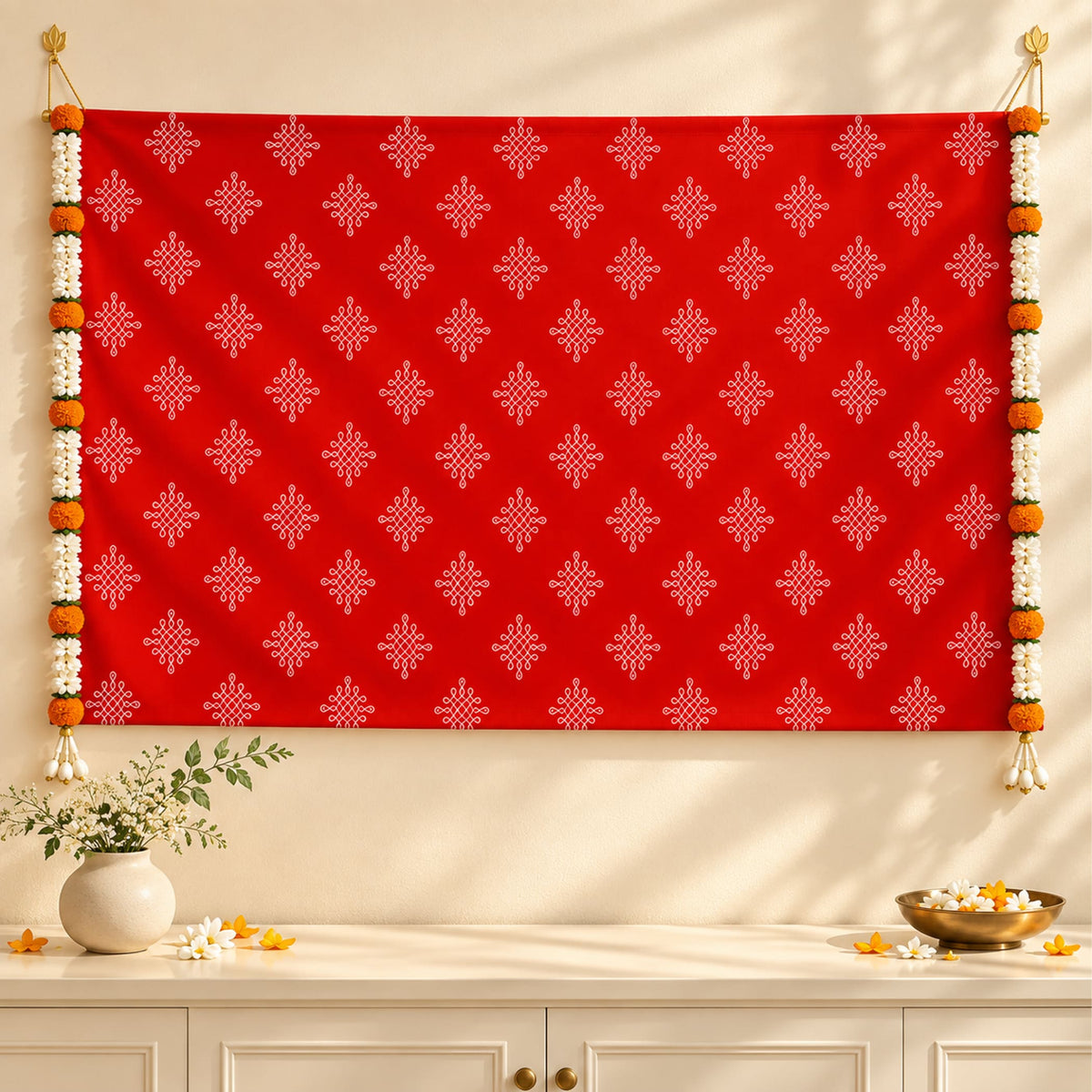 Vibrant red kolam rangoli print backdrop with intricate white geometric patterns and artificial marigold jasmine garlands