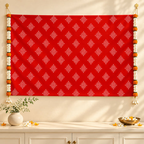 Vibrant red kolam rangoli print backdrop with intricate white geometric patterns and artificial marigold jasmine garlands