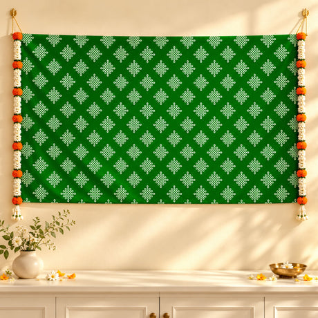 Green tapestry kolam rangoli print backdrop with white geometric patterns and orange white floral garlands for diwali and weddings