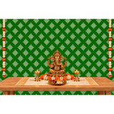 Golden ganesha statue with intricate detailing seated in a meditative pose on kolam rangoli backdrop with marigold garlands