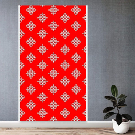 A vibrant red kolam rangoli backdrop panel with intricate white geometric designs and artificial marigold and jasmine garlands for diwali and festive decorations