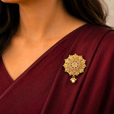 Gold-colored intricate kundan sari brooch with sunburst design and pearl accent for indian bridal wedding accessories