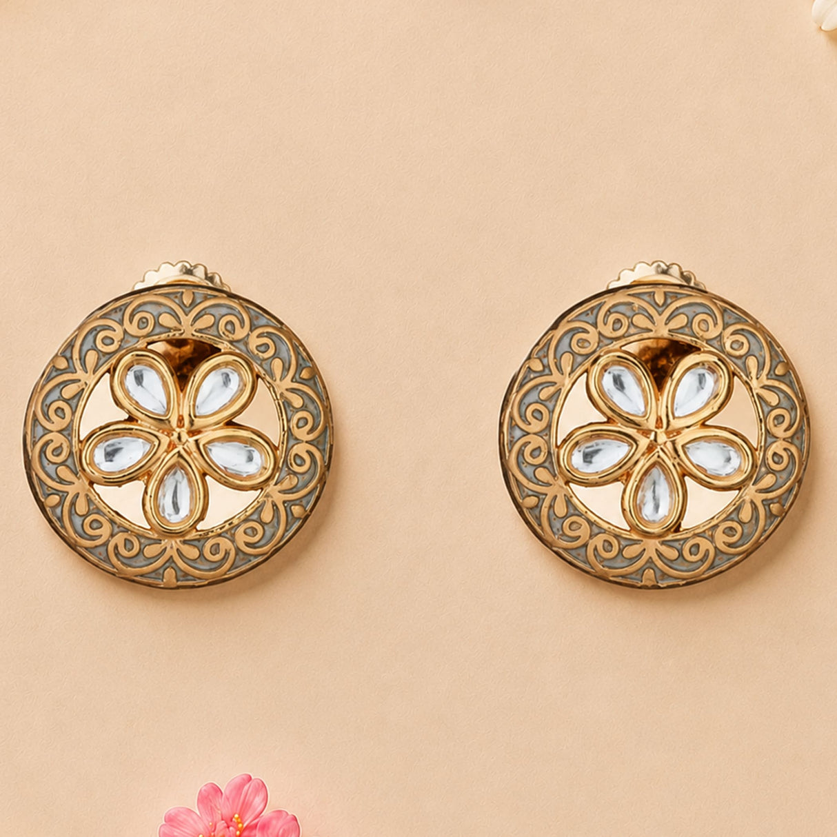 Indian kundan stud earrings in gold tone with intricate filigree and floral arrangement of clear teardrop stones
