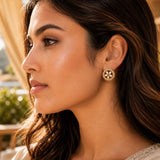 Gold-toned Indian kundan stud earring with intricate floral design and central white stone for bridal wear