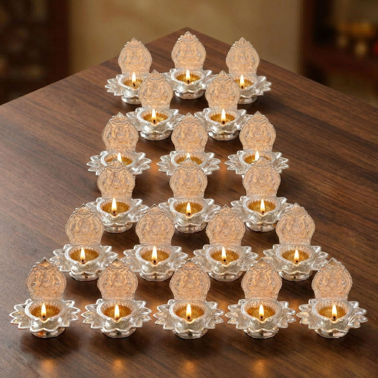 Silver lotus-shaped silver plated diya oil lamps with intricate engravings and glowing candles for diwali puja decor