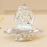 Silver-plated lakshmi diya with intricate embossed seated deity and lotus petal base for puja and diwali decor