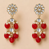 Gold tone indian floral kundan stone earrings with clear stones red gemstones and faux pearls for diwali wedding wear