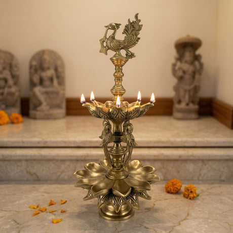 Large parrot brass oil diya with intricate peacock and lotus design featuring five lit candles for puja and home decor